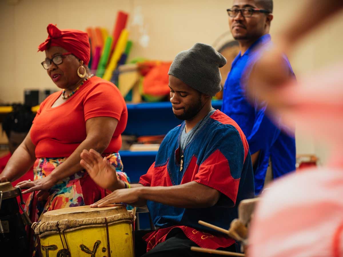 A dancer from Afoutayi Haitian Dance, Music, and Arts performs in a schoolroom.